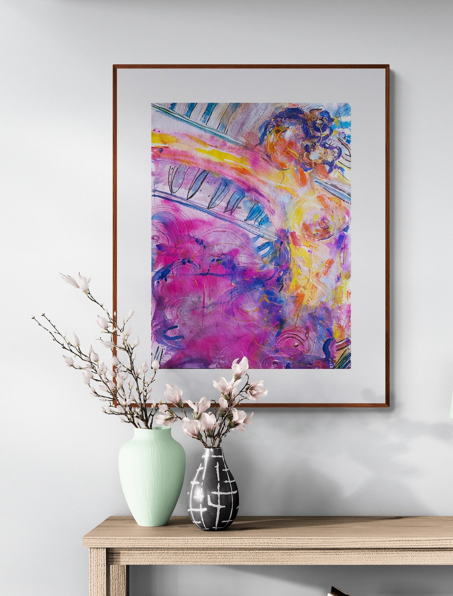 Abstract painting of figure woman  framed and hanging on a wall above a table with flowers 