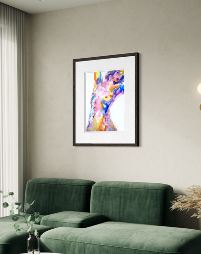 A framed abstract art print featuring a colorful female figure in a black frame and white mat, displayed on a beige wall above a green velvet sofa.