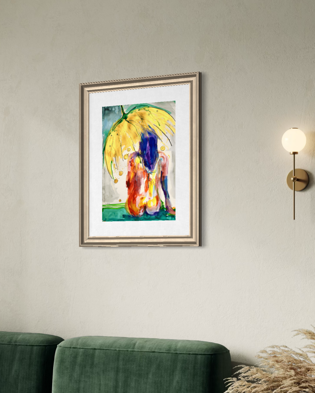 A framed abstract painting of two figures under a yellow umbrella, displayed on a light gray wall above a green sofa with a wall sconce to the right.