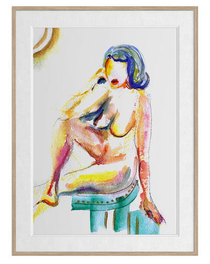 A framed watercolor-style art print depicting a seated nude figure with colorful brushstrokes in blue, yellow, pink, and green on a white background, enclosed in a light wood frame.